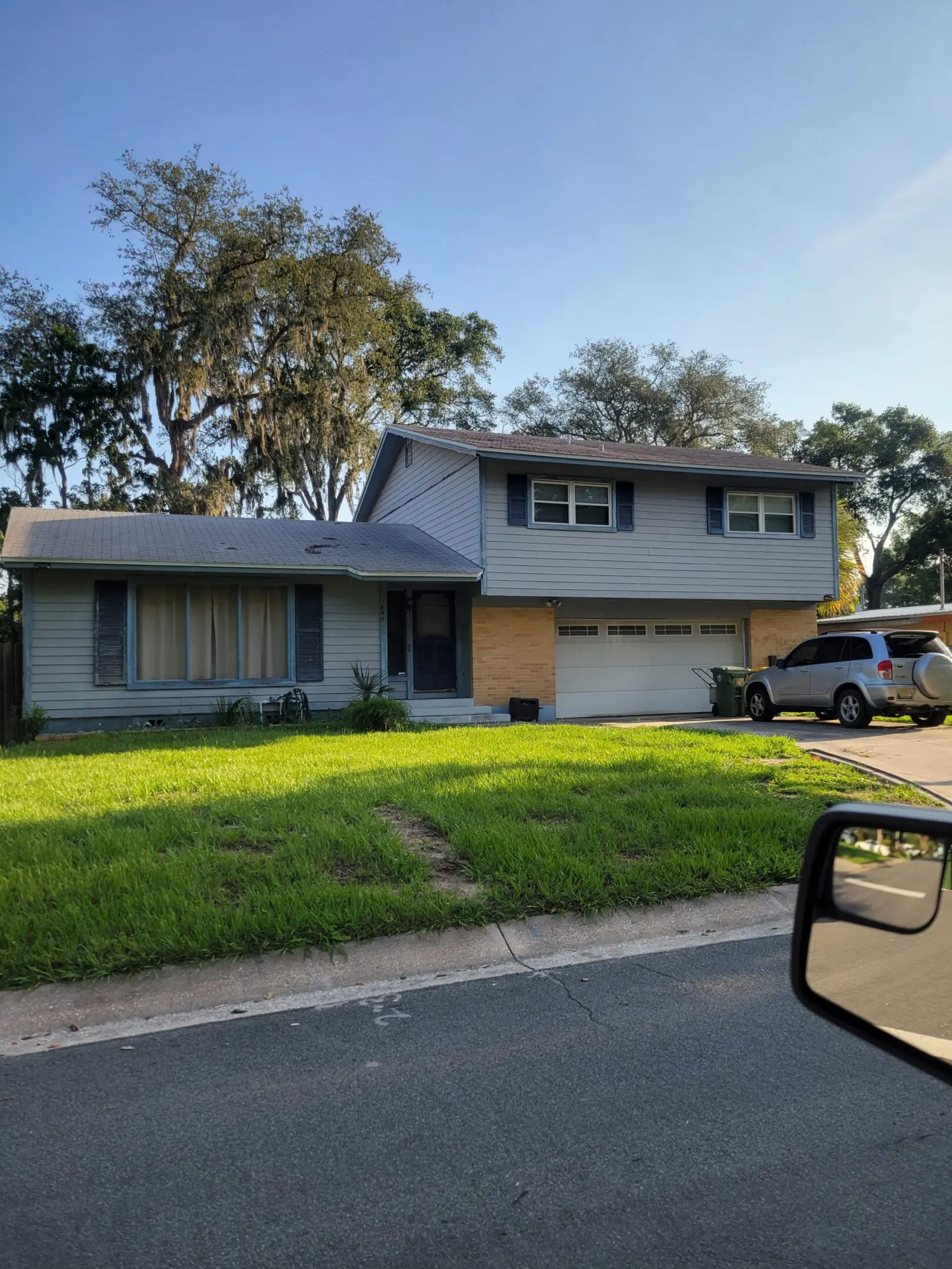 Two-story house with a truck parked outside on a sunny day.
